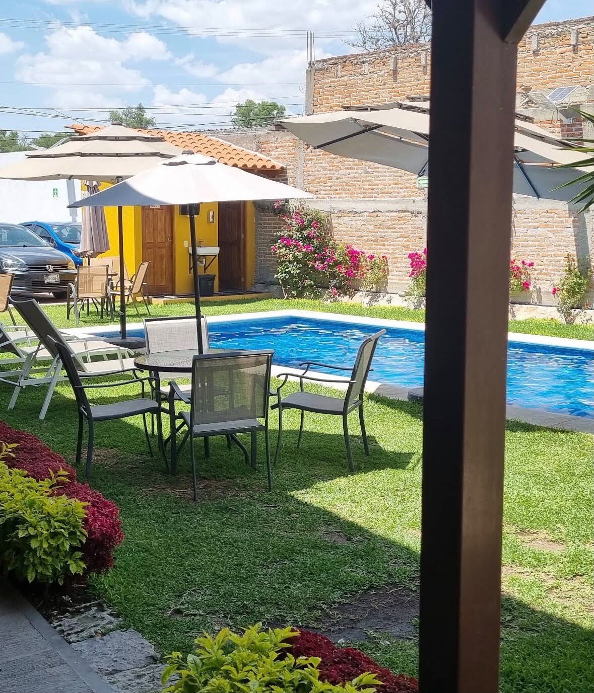 Jardín con mesas y alberca durante el día